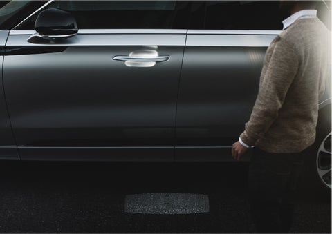 A person approaches a 2023 Lincoln Aviator® Grand Touring as the Lincoln Embrace sequence of welcome lighting illuminates | White's Canyon Motors - Lincoln in Spearfish SD