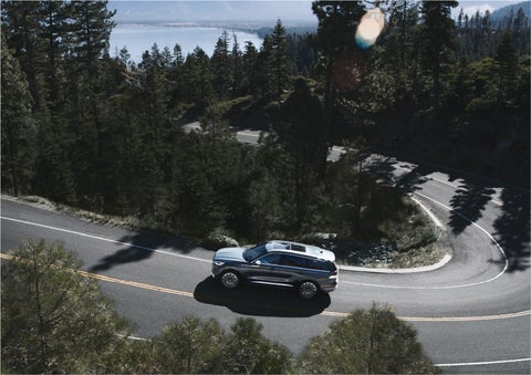A 2023 Lincoln Aviator® SUV is being driven on a winding mountain road | White's Canyon Motors - Lincoln in Spearfish SD