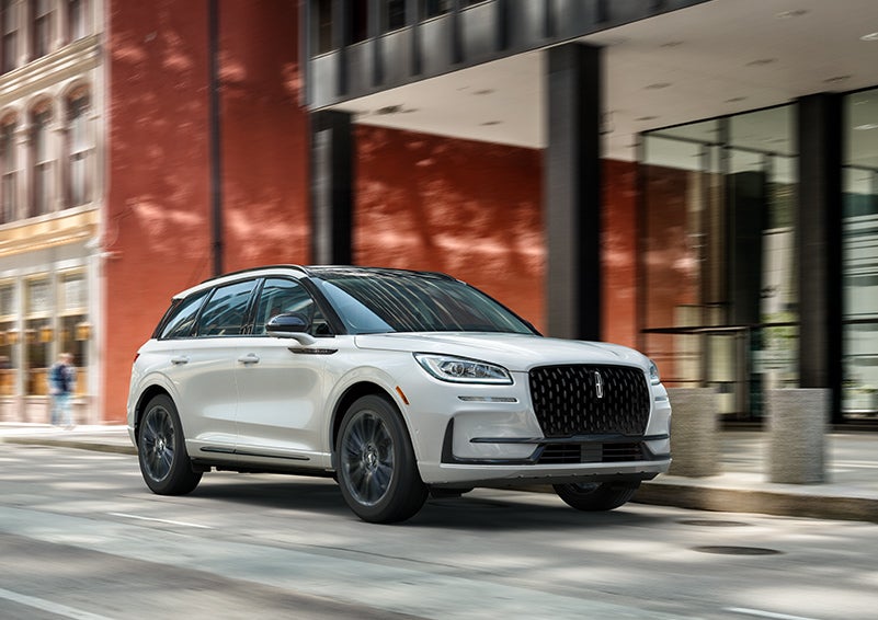 The 2024 Lincoln Corsair® SUV with the Jet Appearance Package and a Pristine White exterior is parked on a city street. | White's Canyon Motors - Lincoln in Spearfish SD