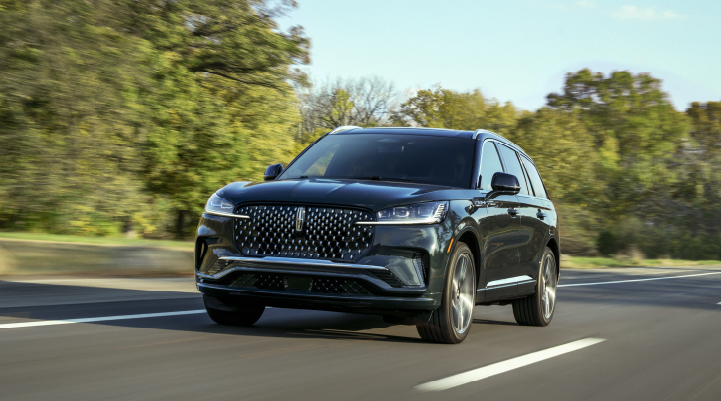 A 2025 Lincoln Black Label Aviator® SUV is being driven down a road lined with trees. | White's Canyon Motors - Lincoln in Spearfish SD