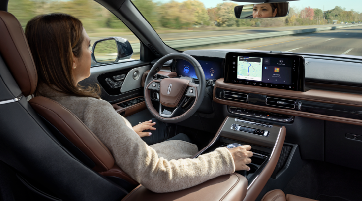 A woman is seen sitting in the driver’s seat of her 2025 Lincoln Aviator® SUV with her hands off the steering wheel. | White's Canyon Motors - Lincoln in Spearfish SD