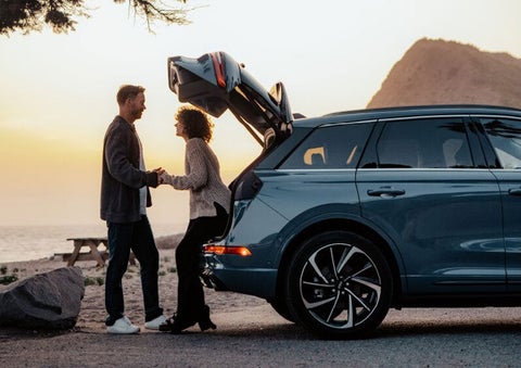 A couple share a moment together outside a 2025 Lincoln Corsair® SUV near the open liftgate. | White's Canyon Motors - Lincoln in Spearfish SD