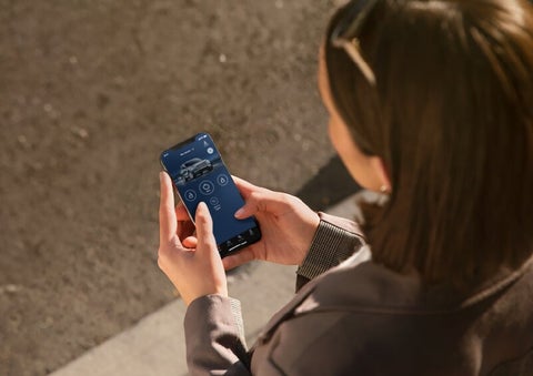 A person is shown interacting with a smartphone to connect to a Lincoln vehicle via the Lincoln Way® App. | White's Canyon Motors - Lincoln in Spearfish SD