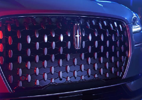 The grille of a 2025 Lincoln Corsair® SUV reflects neon light at night. | White's Canyon Motors - Lincoln in Spearfish SD