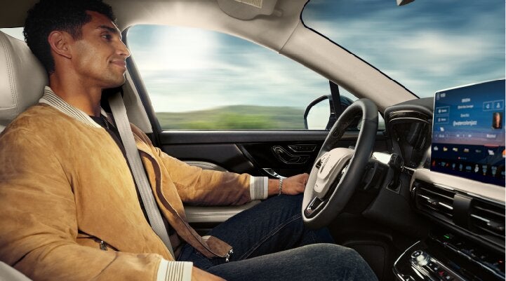 A person is shown using Lincoln BlueCruise hands-free highway driving technology on a divided highway called a Hands-Free Blue Zone. | White's Canyon Motors - Lincoln in Spearfish SD