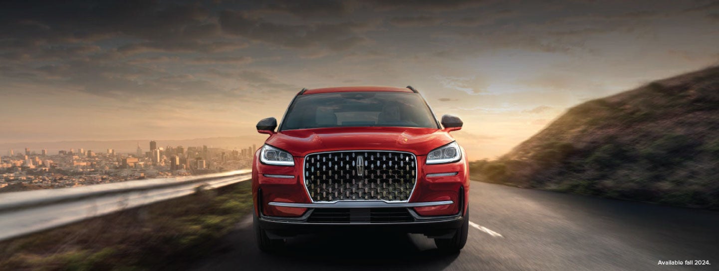 A 2025 red Lincoln Corsair® SUV is being driven down a road at sunset. | White's Canyon Motors - Lincoln in Spearfish SD