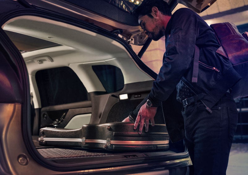 A man is shown loading cargo into the rear of a 2024 Lincoln Corsair® SUV with the second-row seats folded flat. | White's Canyon Motors - Lincoln in Spearfish SD