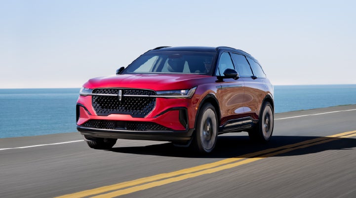 A 2025 Lincoln Nautilus® SUV is being driven on a seaside roadway. | White's Canyon Motors - Lincoln in Spearfish SD