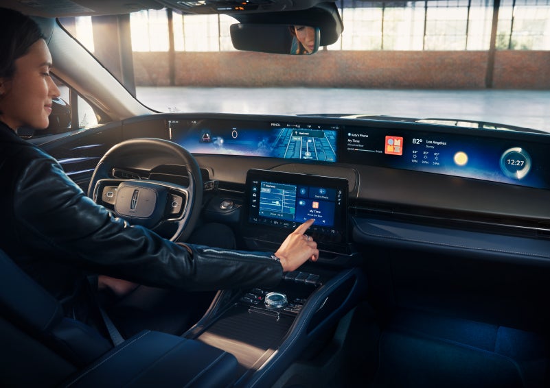 The driver of a 2025 Lincoln Nautilus® SUV interacts with the center touchscreen. | White's Canyon Motors - Lincoln in Spearfish SD