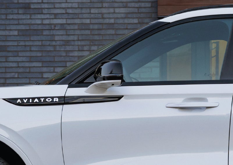 The driver’s side door and fender badging of a white 2026 Lincoln Aviator® SUV are showcased. | White's Canyon Motors - Lincoln in Spearfish SD