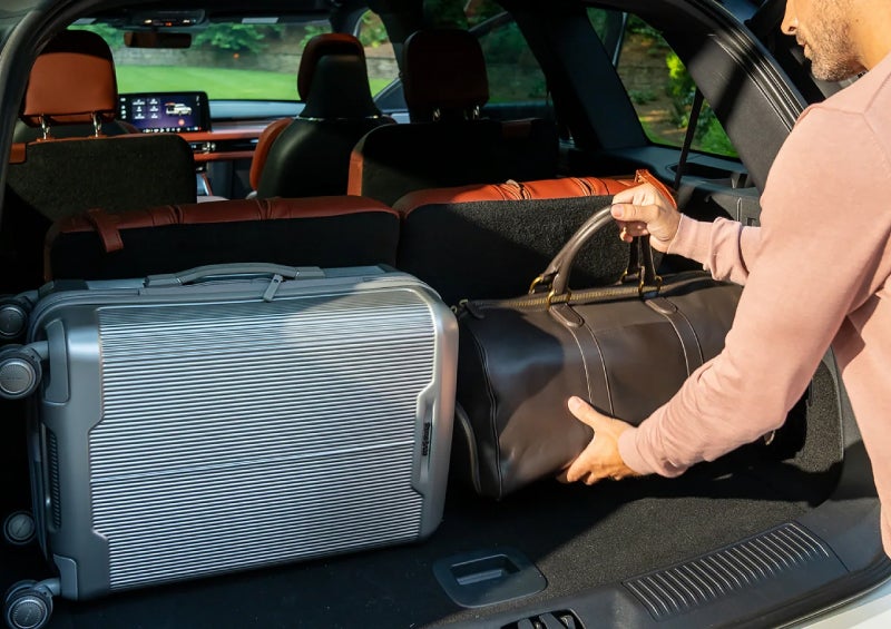 A man loads luggage into the rear of a 2026 Lincoln Aviator® SUV through the opened rear liftgate. | White's Canyon Motors - Lincoln in Spearfish SD
