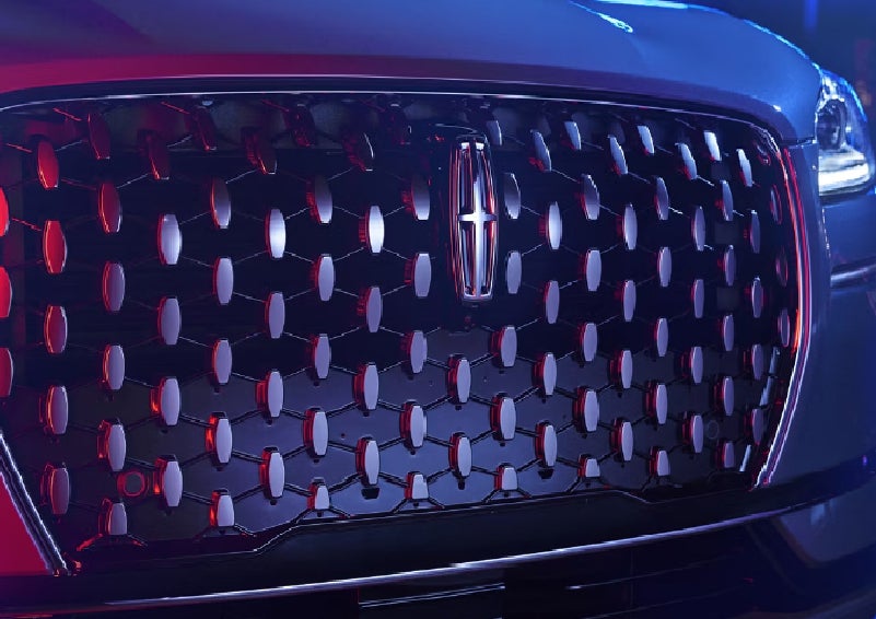 The grille of a 2025 Lincoln Corsair&reg; SUV reflects neon light at night. | White's Canyon Motors - Lincoln in Spearfish SD