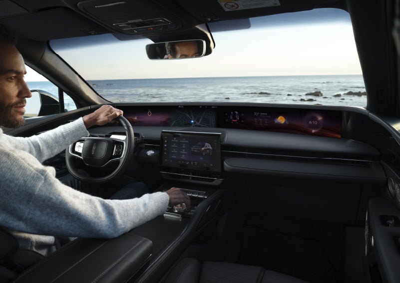 A driver of a parked 2026 Lincoln Nautilus® SUV takes a relaxing moment at a seaside overlook while inside his Nautilus. | White's Canyon Motors - Lincoln in Spearfish SD